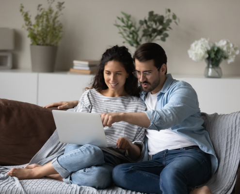 couple doing financial wellness checkup together on laptop